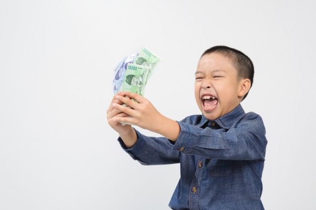 Young boy with happy and smile with korean won bank note on white background